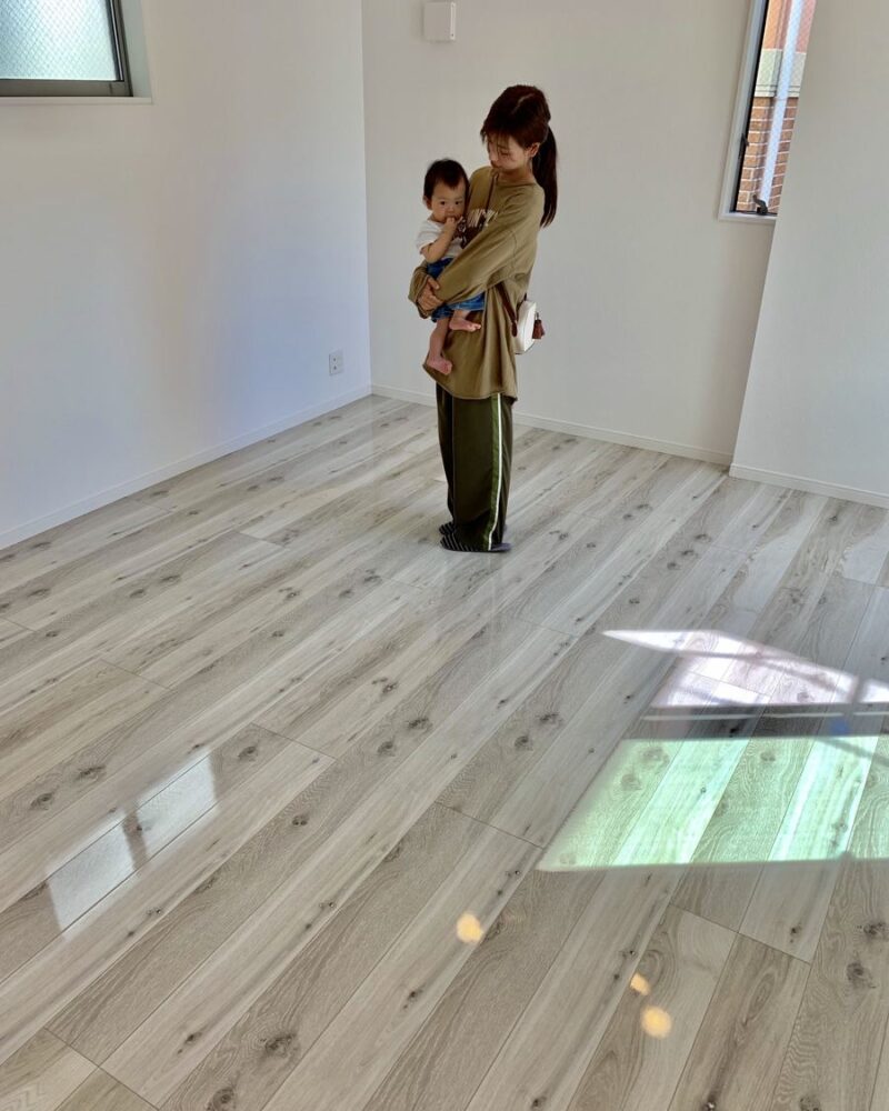 東京都足立区のご新築戸建てで施工後の床とお客様（UVフロアコーティング施工後）