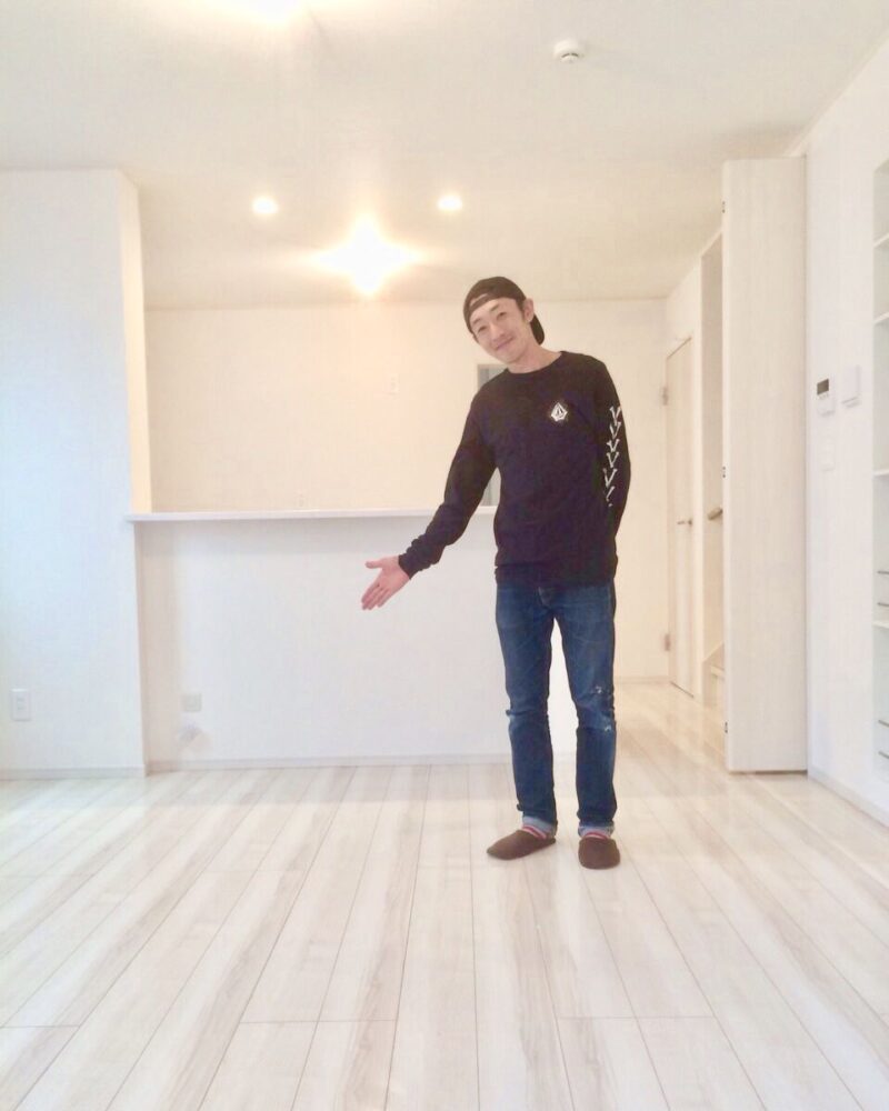 兵庫県姫路市のご新築戸建てで施工後のLDKで床を紹介するお客様（ガラスフロアコーティング施工後）
