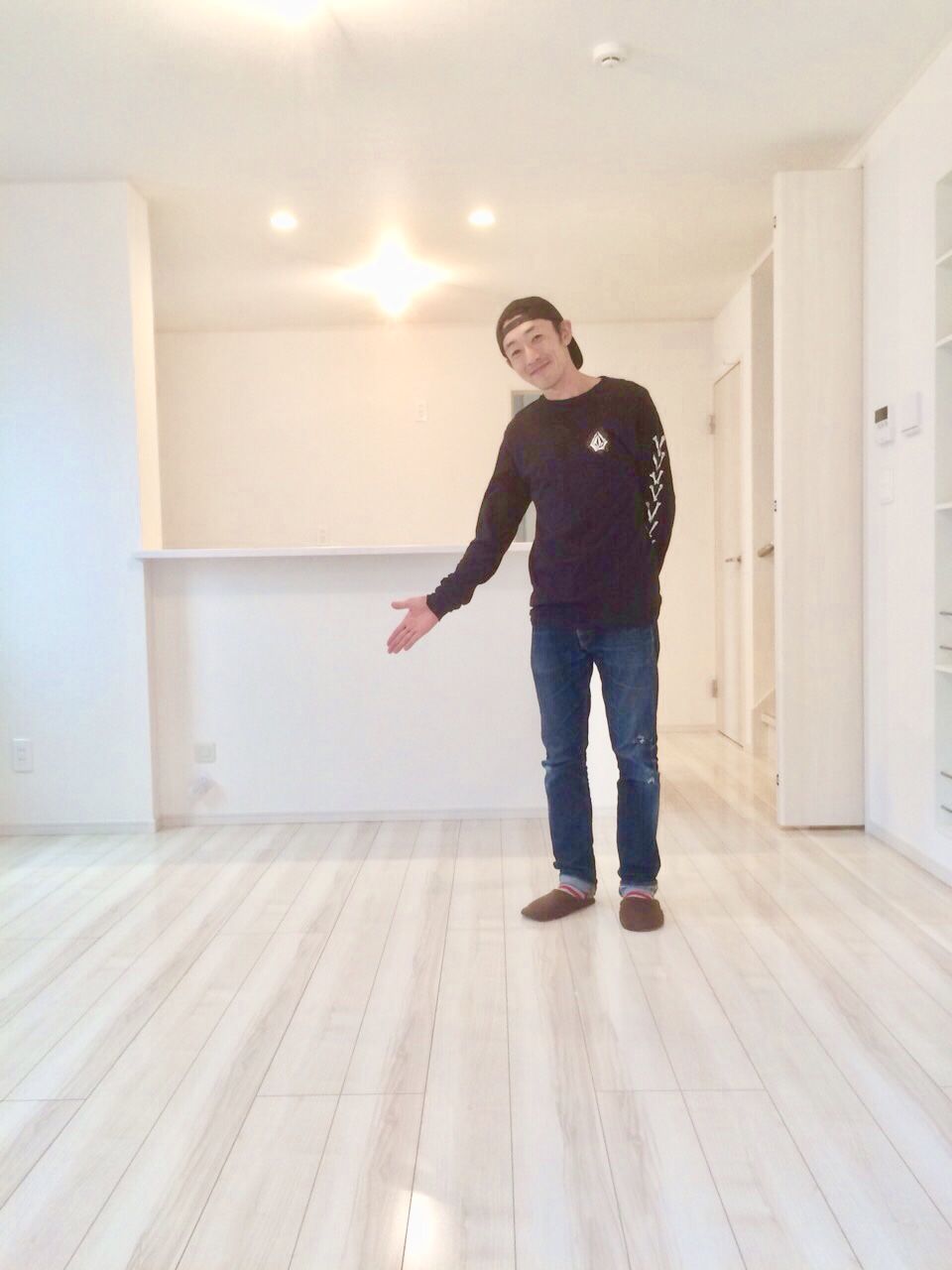 兵庫県姫路市のご新築戸建てで施工後のLDKで床を紹介するお客様（ガラスフロアコーティング施工後）
