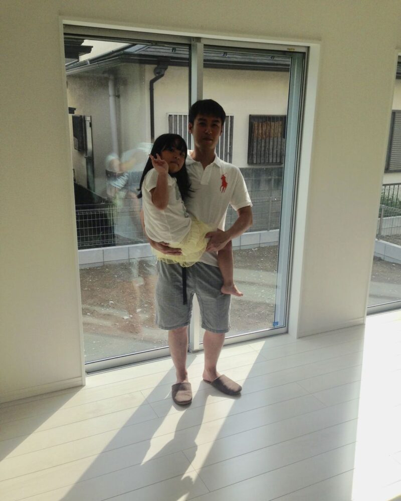 東京都文京区のご新築マンションで施工後の洋室でお子さまを抱くお客様（セラミックガラスフロアコーティング（微光沢）施工後）