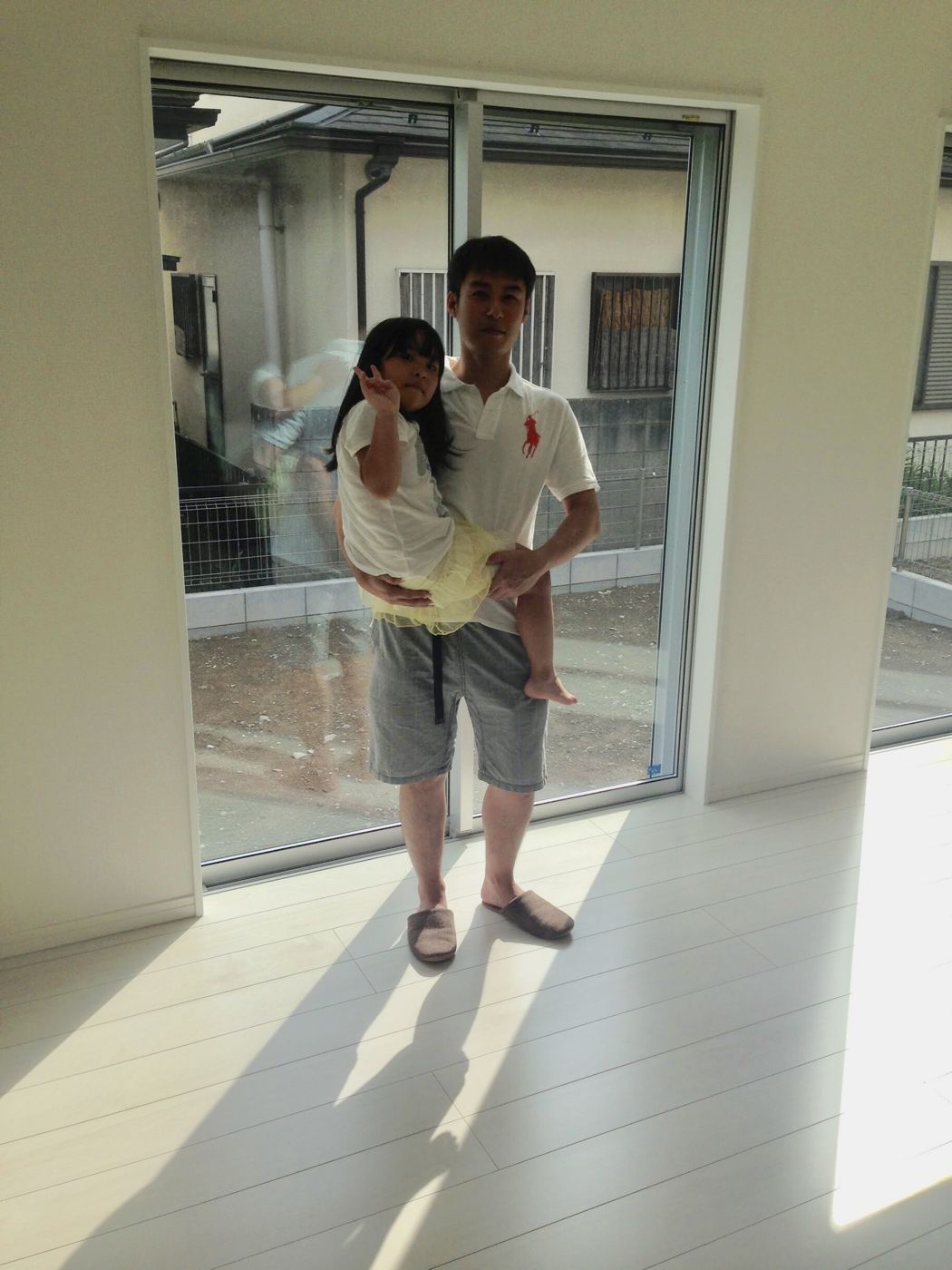 東京都文京区のご新築マンションで施工後の洋室でお子さまを抱くお客様(セラミックガラスフロアコーティング(微光沢)施工後)