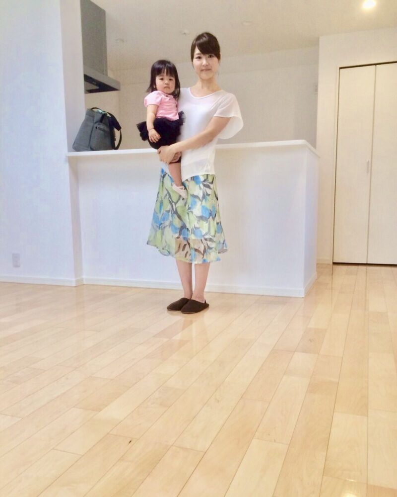 千葉県千葉市美浜区のご新築マンションで施工後のLDKでお子さまを抱くお客様（セラミックガラスフロアコーティング（微光沢）施工後）