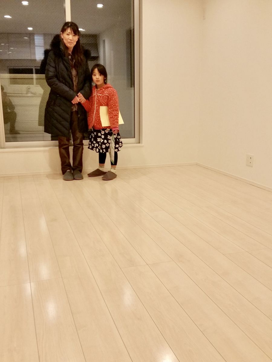 東京都中央区のご新築戸建てで施工後の床とお客様(シリコンフロアコーティング施工後)