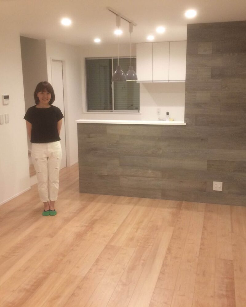 東京都府中市のご新築戸建てで施工後のLDKに立つお客様（セラミックガラスフロアコーティング（微光沢）施工後）