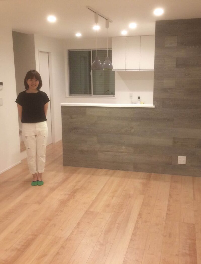 東京都府中市のご新築戸建てで施工後のLDKに立つお客様（セラミックガラスフロアコーティング（微光沢）施工後）