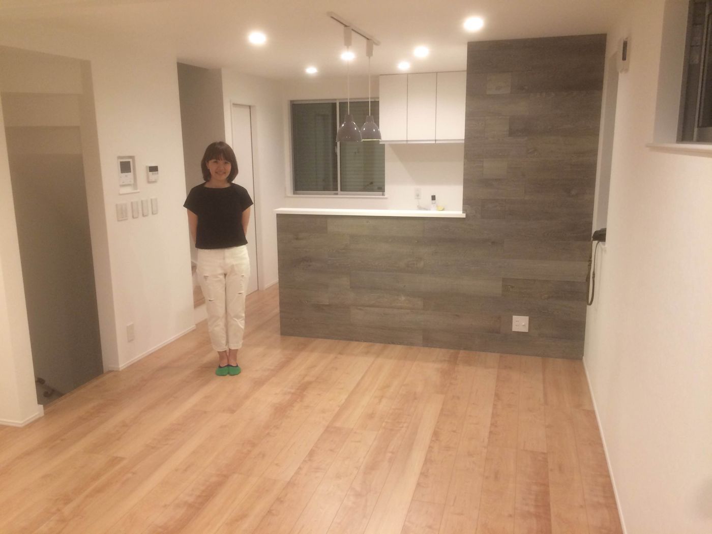東京都府中市のご新築戸建てで施工後のLDKに立つお客様(セラミックガラスフロアコーティング(微光沢)施工後)