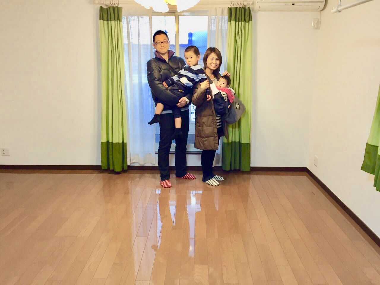 千葉県船橋市のご新築マンションで施工後のリビングに立つご家族(シリコンフロアコーティング施工後)