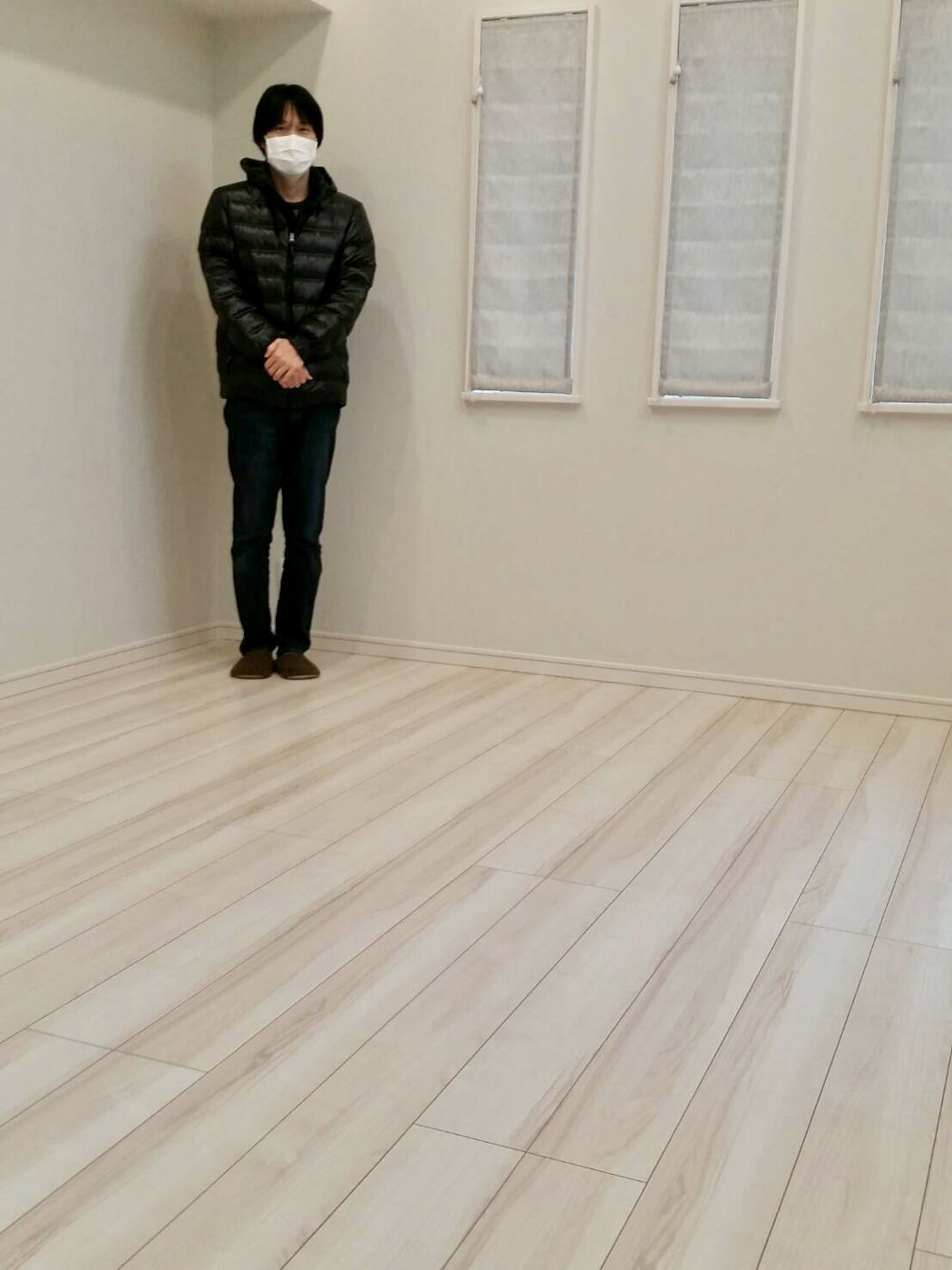 神奈川県平塚市のご新築戸建てで施工後の洋室に立つお客様（ガラスフロアコーティング施工後）
