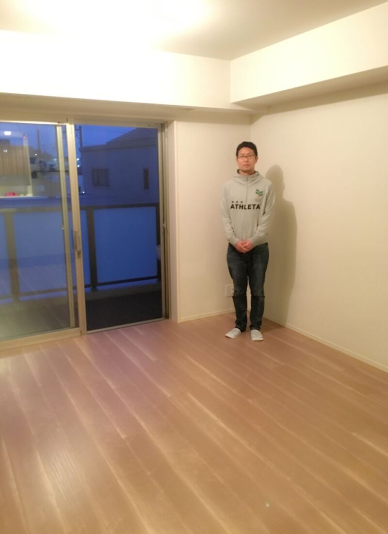 神奈川県川崎市中原区のご新築戸建てで施工後の洋室に立つお客様（ガラスフロアコーティング施工後）