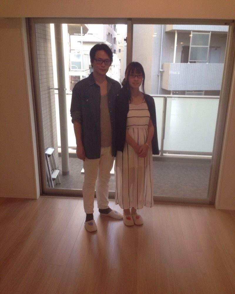 東京都江東区のリノベーション済みマンションで施工後のリビングに立つご夫婦（ガラスフロアコーティング施工後）