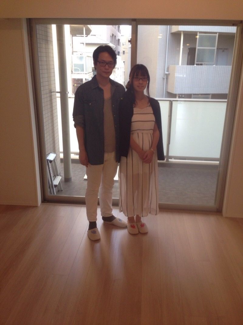 東京都江東区のリノベーション済みマンションで施工後のリビングに立つご夫婦（ガラスフロアコーティング施工後）