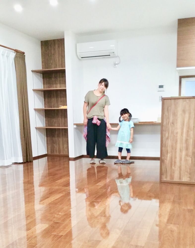 東京都港区のリノベーション済みマンションで施工後の光沢のある床に立つご家族（セラミックガラスフロアコーティング（光沢）施工後）