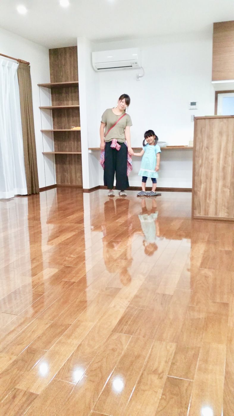 東京都港区のリノベーション済みマンションで施工後の光沢のある床に立つご家族(セラミックガラスフロアコーティング(光沢)施工後)