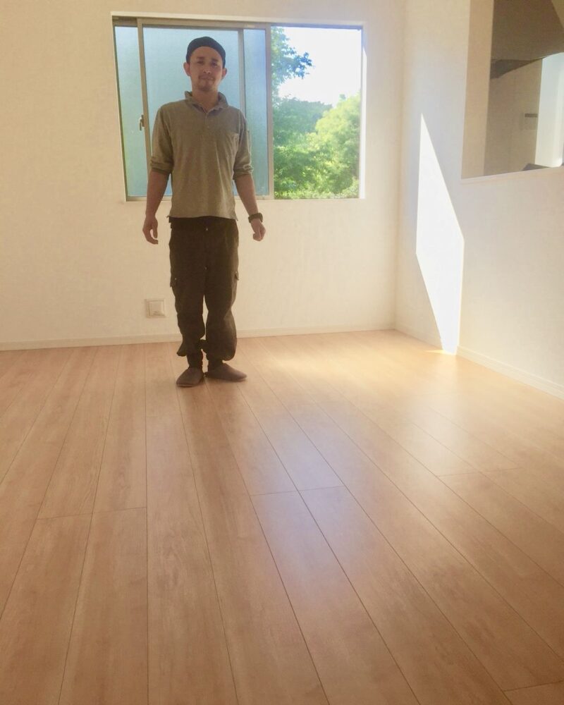 東京都港区のリノベーション済みマンションで施工後の明るい床に立つお客様（ワンニャンすべらんフロアコーティング施工後）
