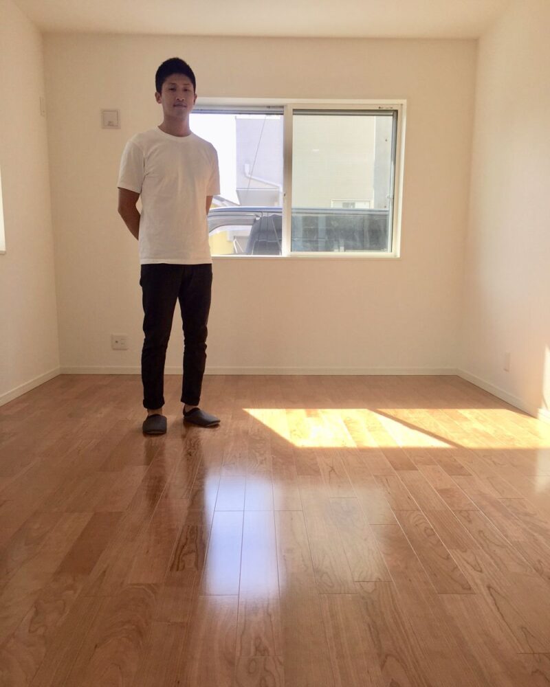 愛知県名古屋市千種区のご新築マンションで施工後の洋室に立つお客様（セラミックガラスフロアコーティング（微光沢）施工後）