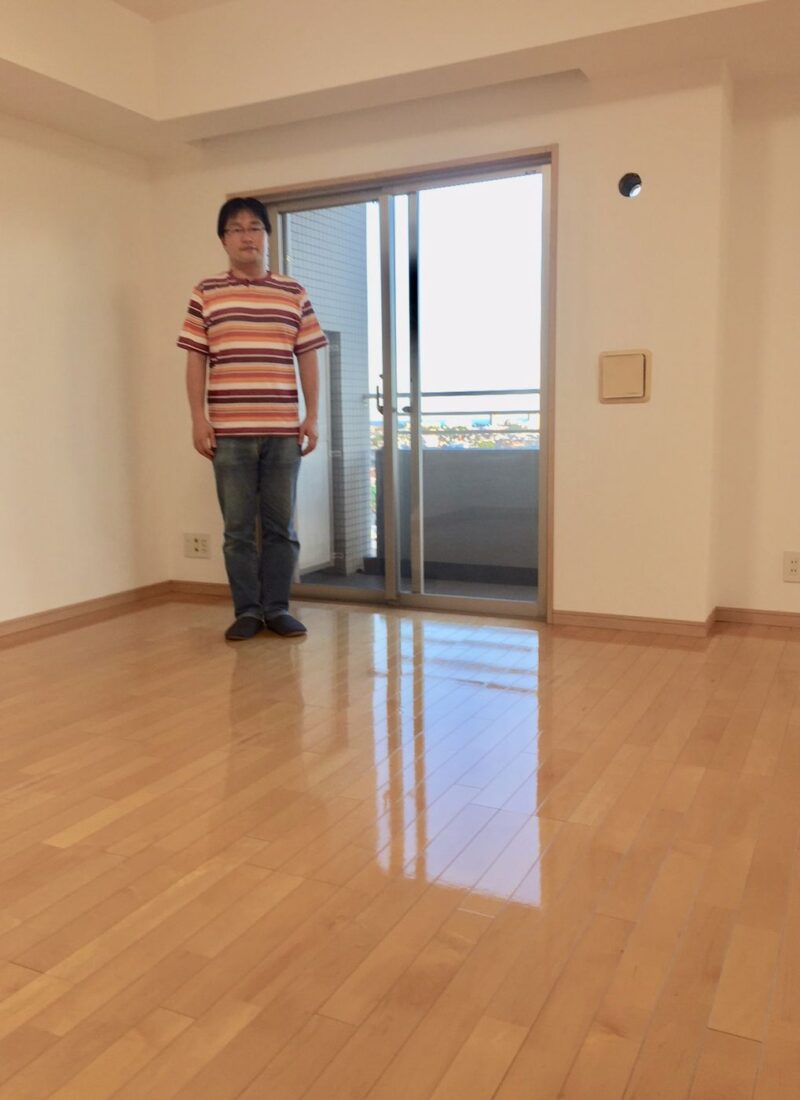 埼玉県さいたま市桜区のリノベーション済みマンション（入居前）で施工後のリビングに立つお客様（セラミックガラスフロアコーティング（微光沢）施工後）
