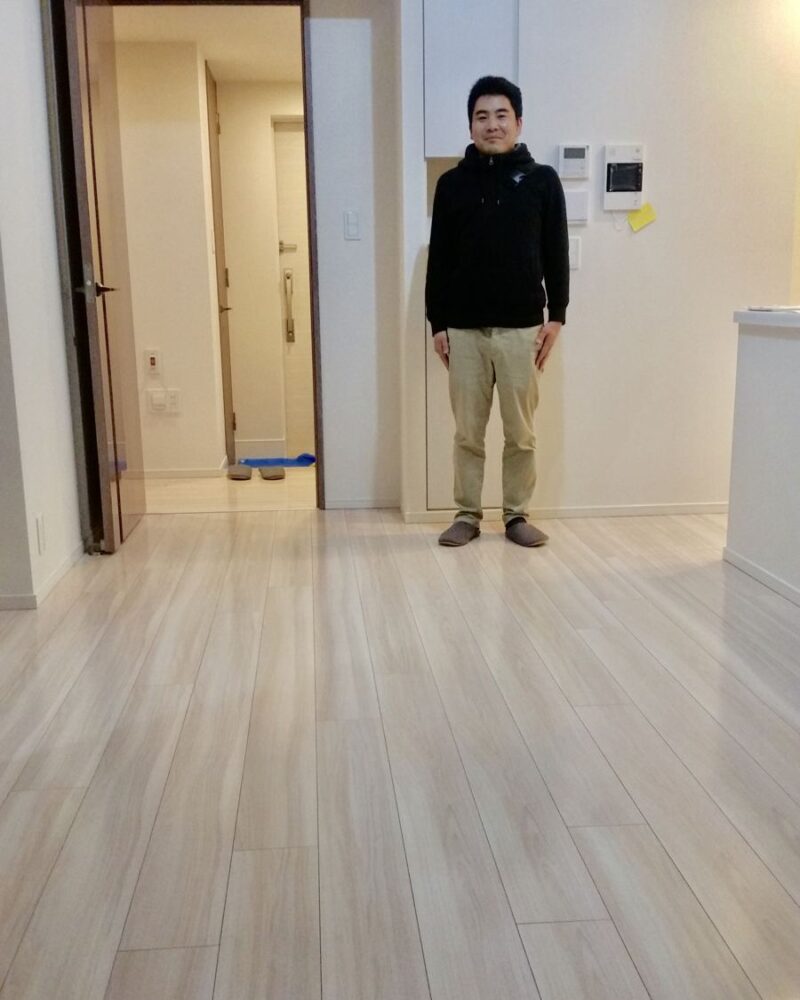 東京都世田谷区のご新築マンションで施工後の床とお客様（ガラスフロアコーティング施工後）