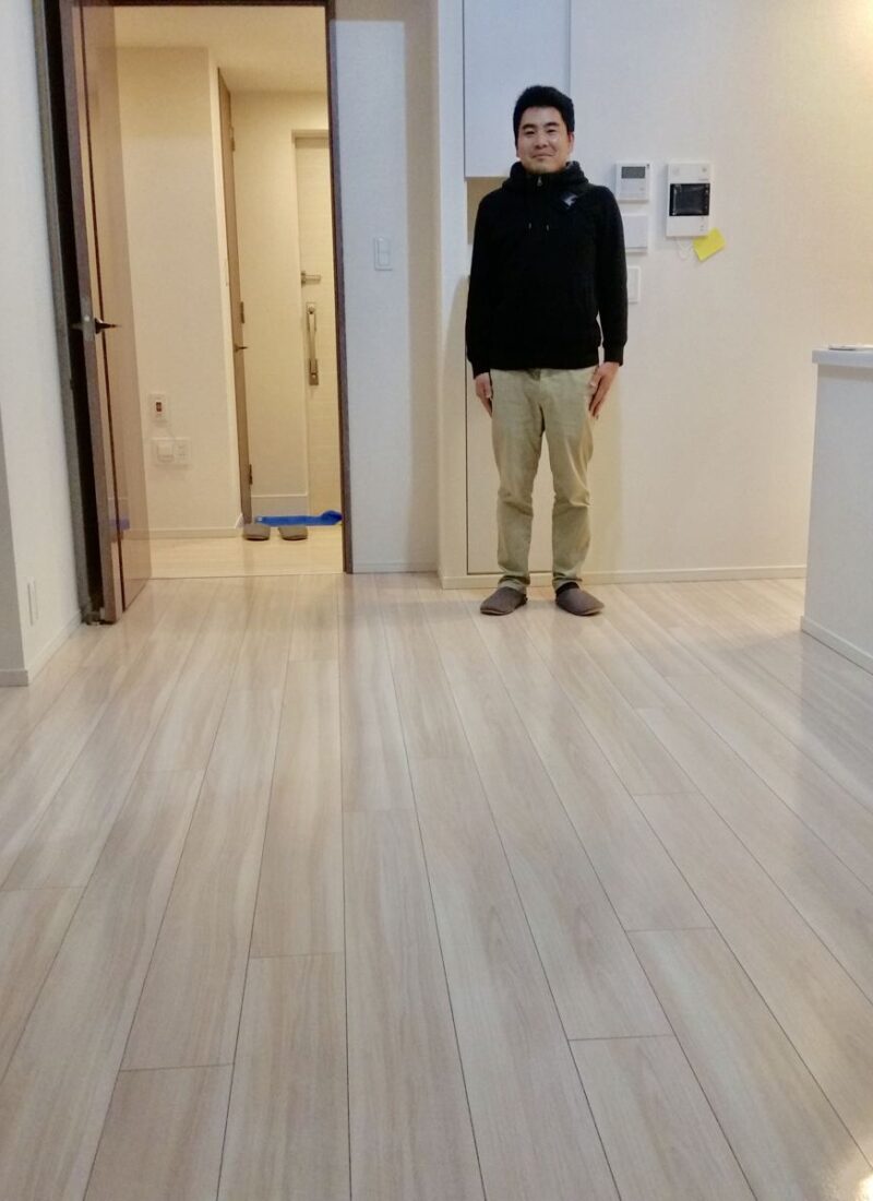 東京都世田谷区のご新築マンションで施工後の床とお客様（ガラスフロアコーティング施工後）