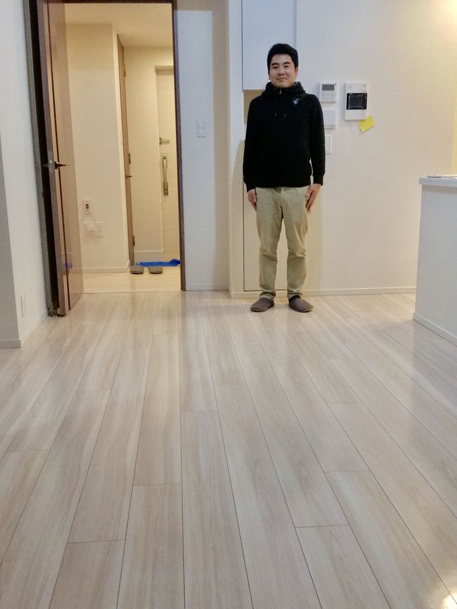 東京都世田谷区のご新築マンションで施工後の床とお客様（ガラスフロアコーティング施工後）