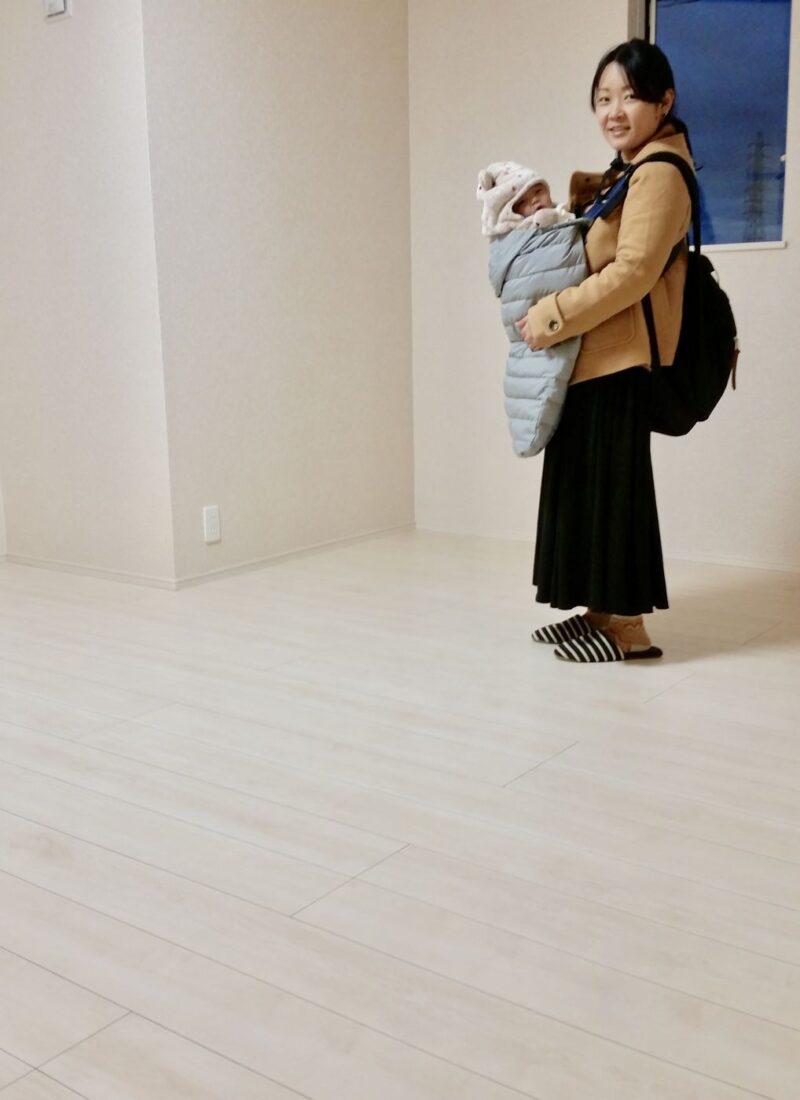 東京都世田谷区のご新築戸建てで施工後の明るい床で赤ちゃんを抱くお客様（ワンニャンすべらんフロアコーティング施工後）