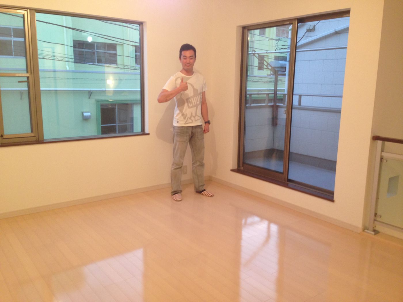 群馬県高崎市の中古マンションで施工後の洋室で笑顔のお客様(ワンニャンすべらんフロアコーティング施工後)