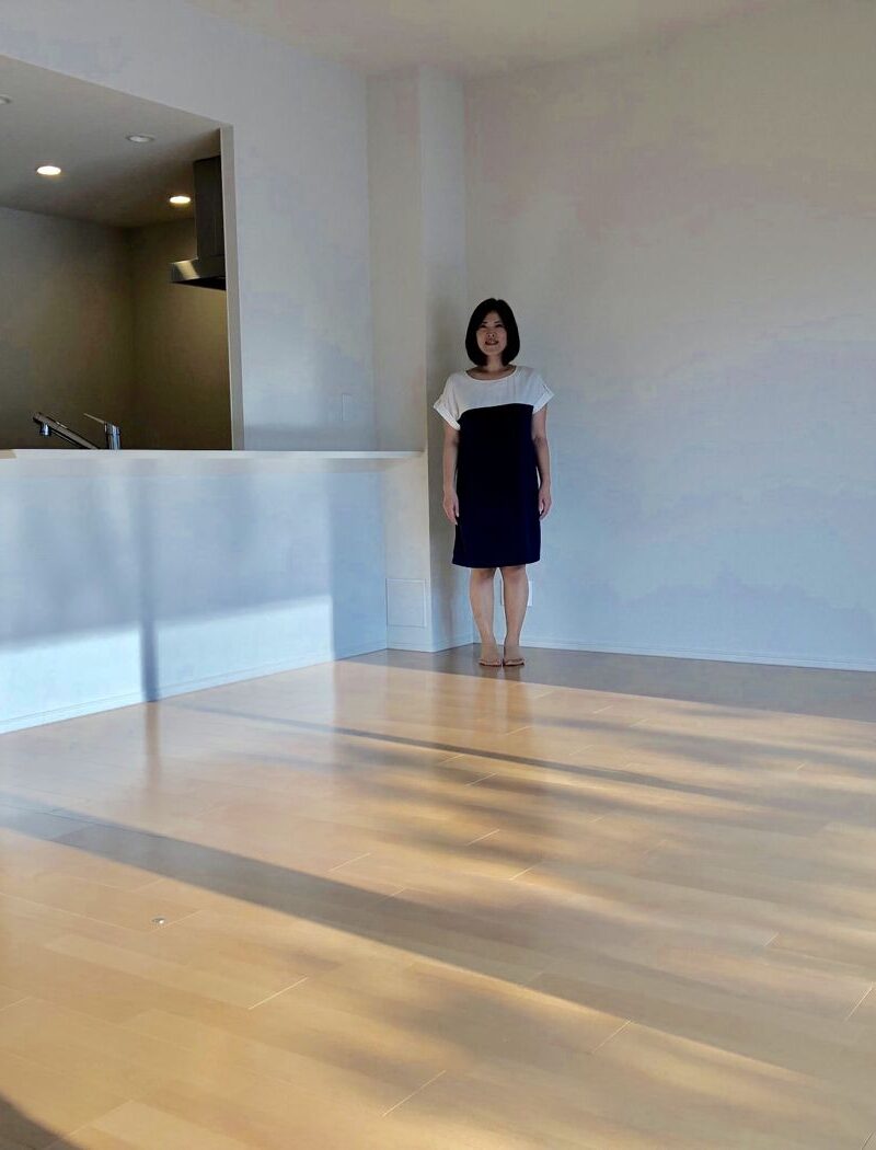 栃木県宇都宮市のご新築戸建てで施工後のLDKに立つお客様（シリコンフロアコーティング施工後）