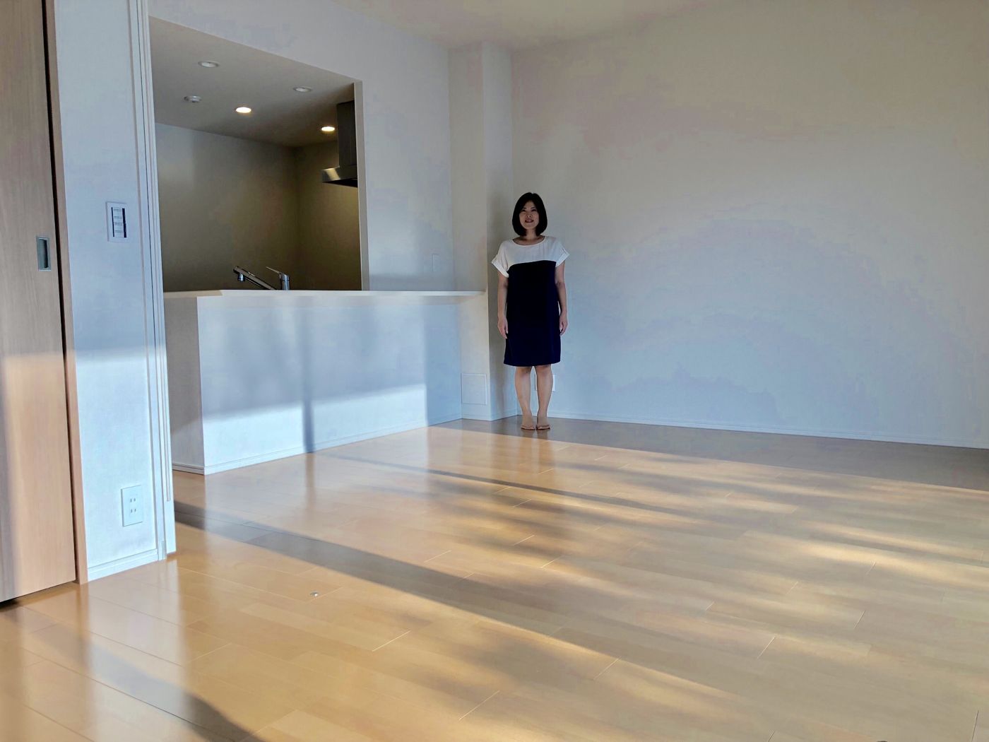 栃木県宇都宮市のご新築戸建てで施工後のLDKに立つお客様(シリコンフロアコーティング施工後)