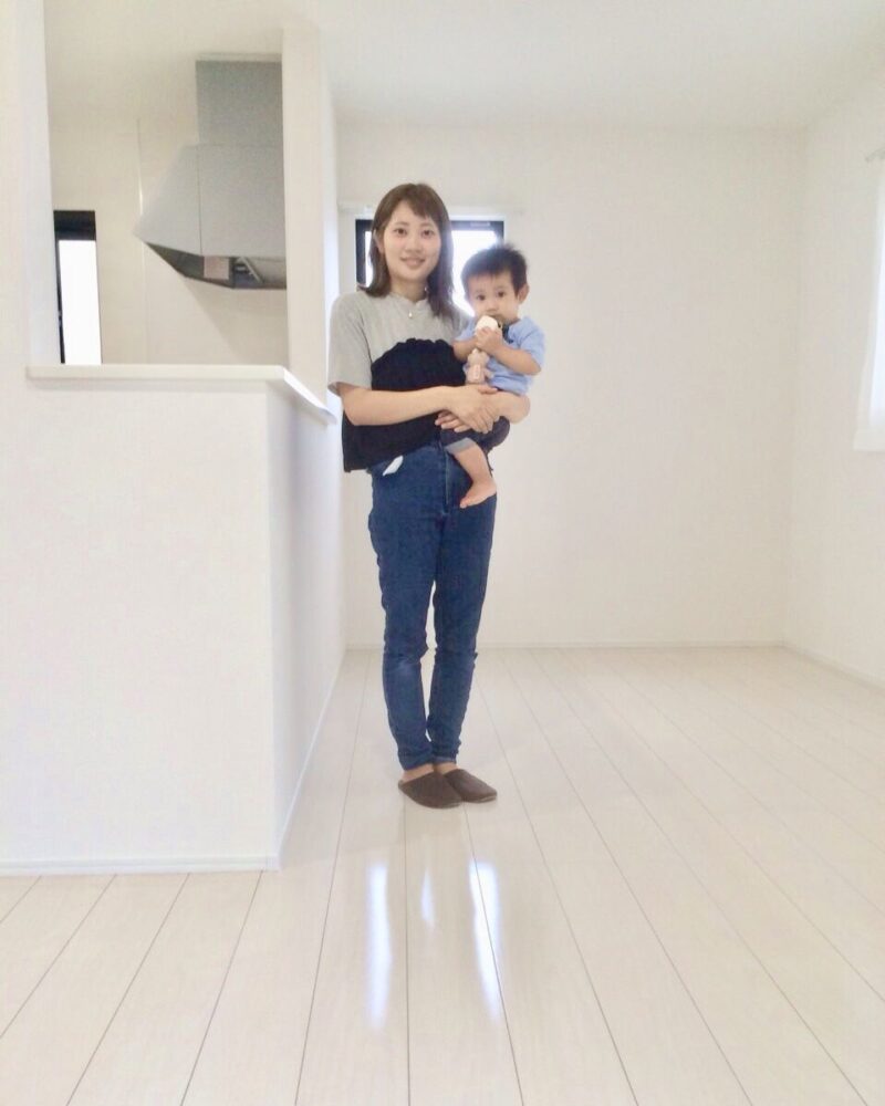千葉県八街市のご新築戸建てで施工後のLDKでお子さまを抱くお客様（セラミックガラスフロアコーティング（微光沢）施工後）