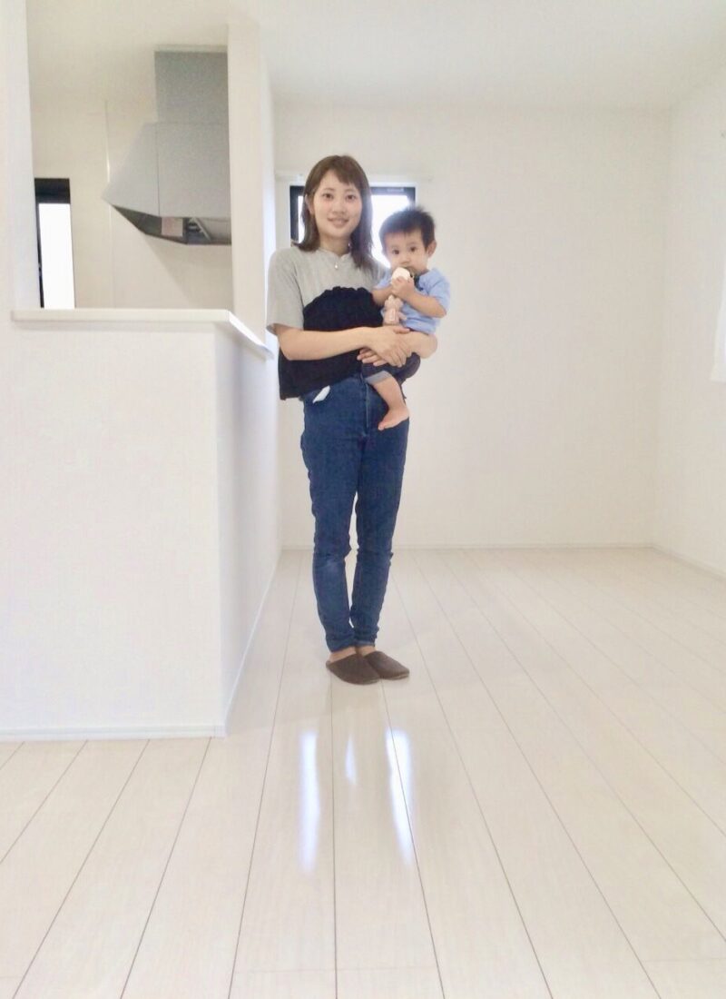 千葉県八街市のご新築戸建てで施工後のLDKでお子さまを抱くお客様（セラミックガラスフロアコーティング（微光沢）施工後）