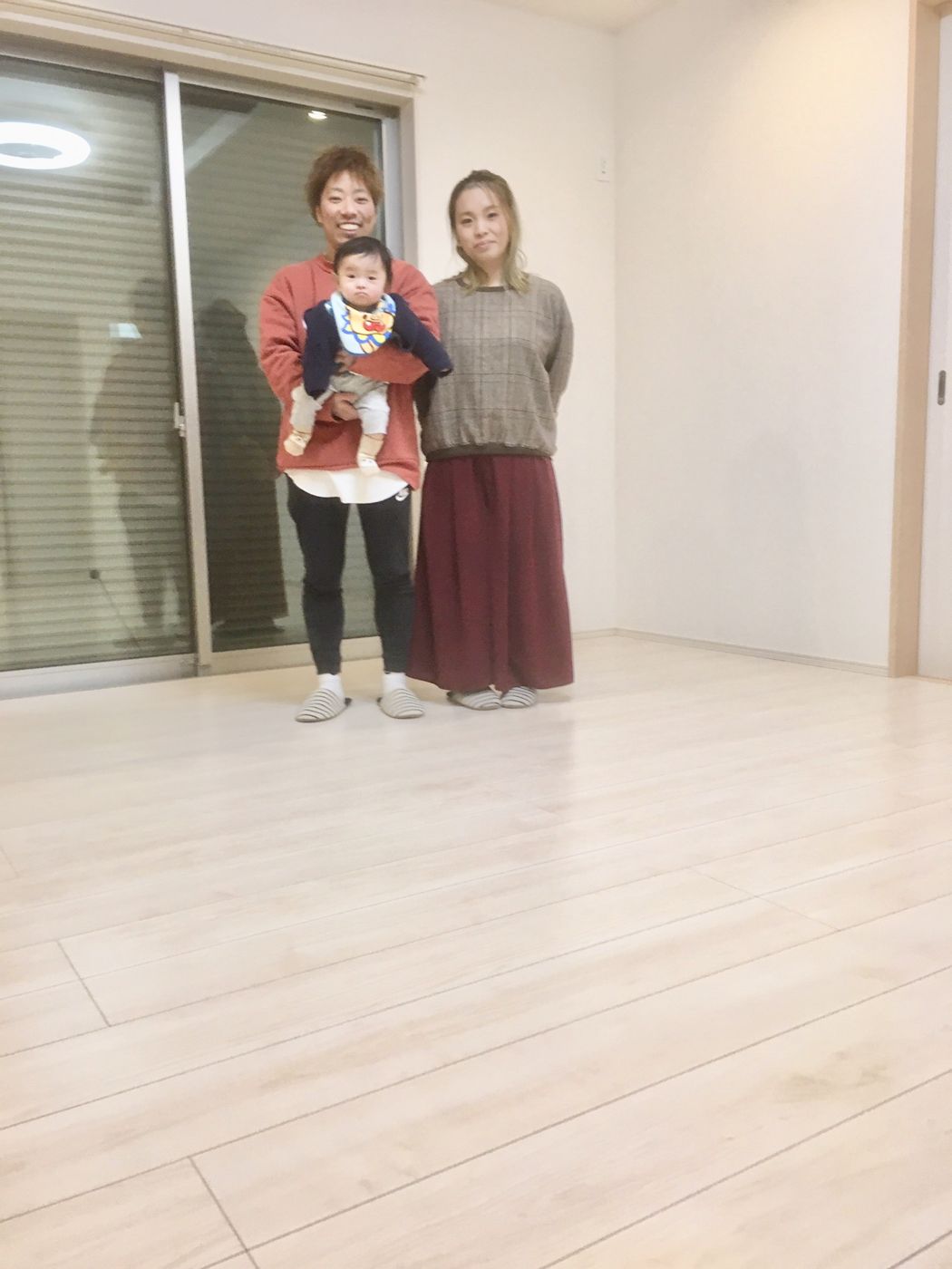 神奈川県横浜市港北区のご新築戸建てで施工後の明るい床に立つご家族(セラミックガラスフロアコーティング(微光沢)施工後)