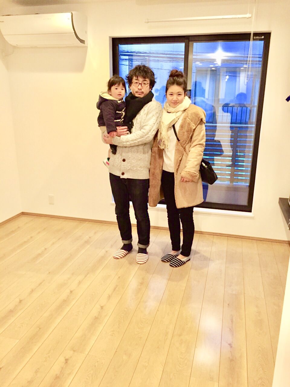 神奈川県横浜市戸塚区のご新築マンションで施工後の洋室に立つご家族(セラミックガラスフロアコーティング(微光沢)施工後)